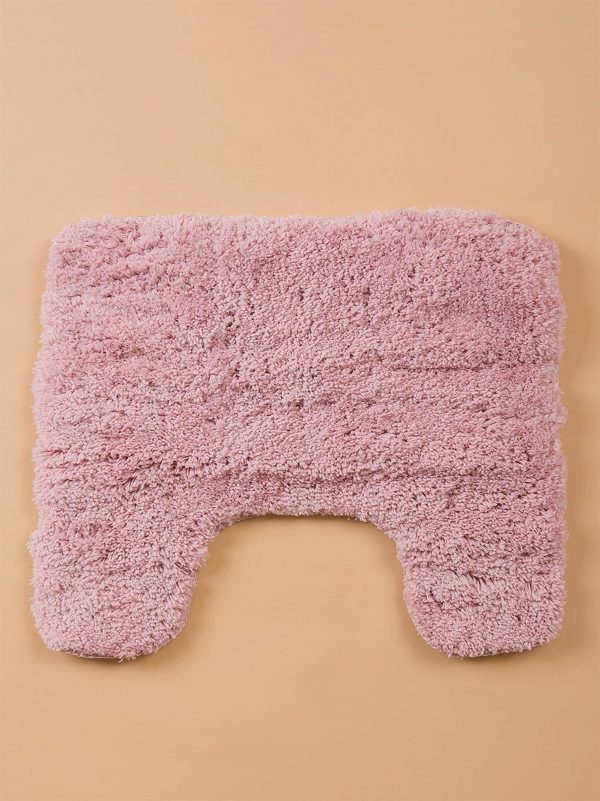 Pink bathroom mat under toilet